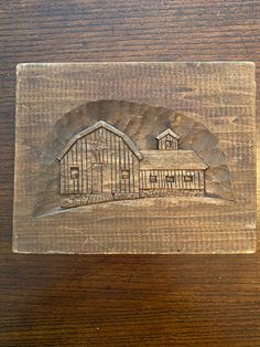 a piece of wood with a drawing of a barn on it