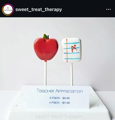 there are two candy apples on sticks with writing and an apple in the middle that says sweet treat therapy