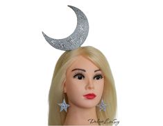 Moon headpiece  Halloween glitter moon stars crown Festival white glitter headband and earrings Celestial headpiece  Halloween moon headdress Other Holiday headbands  https://www.etsy.com/shop/DekorLiuSy?ref=seller-platform-mcnav&section_id=23780040 The accessory is made by hand from glitter eva foam. It is soft and lightweight material. At the base is a metal hairband of standard size. Whimsical Cat Ears Headband For Parties, Moon Costume Diy, Moon Headdress, Moon Headpiece, Celestial Headpiece, Stars Crown, Metal Hairband, Moon Hat, Patriotic Costumes