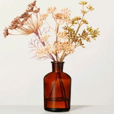 a brown vase filled with flowers on top of a table