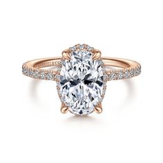 an oval cut engagement ring with pave diamonds on the band and center stone in rose gold