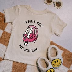 there is a pair of slippers next to a t - shirt with a pink bus on it