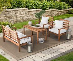 an outdoor patio with wooden furniture and white pillows