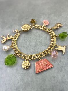 a gold bracelet with charms on it that says have hope laugh written in pink and green