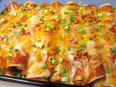 a casserole dish with cheese, green onions and meat toppings on it