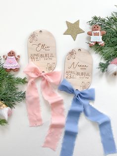 three wooden tags with names on them next to pine branches and other decorations including teddy bears