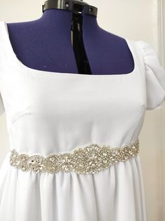 Beautiful white chiffon dress with large rhinestone applique on the front. Dress in the Bridgerton style of the early 1800s. Manufacture of the dress in 4 weeks. 100% polyester. Beautiful quality white chiffon dress. Fastens with buttons in the back. Small train in the back. The rhinestone belt is only on the front. Available sizes: XXS to 3XL (see table in the photos) Rhinestone-embellished Dresses For Debutante Ball, Elegant White Dresses With Sashes, Fitted Chiffon Dress For Debutante Ball, White Formal Dresses With Sashes, White Wedding Dress With Sashes, Regency Style Dresses For Vintage Events With Empire Waist, Regency Style Empire Waist Dress For Vintage Events, Vintage White Chiffon Dress, White Embellished Dress For Formal Occasions