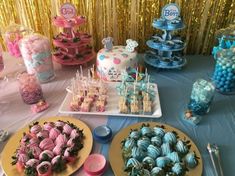 there are many desserts on the table with blue and pink decorations, including marshmallows