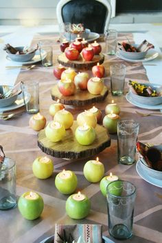 a table topped with plates and bowls filled with apples