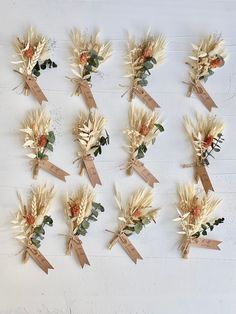 a bunch of dried flowers are arranged on a white surface with tags attached to them