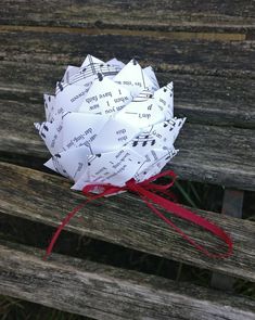 a paper bouquet sitting on top of a wooden bench