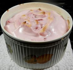 a bowl filled with food sitting on top of a white cloth next to an oven