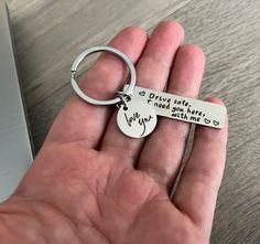 a hand holding a keychain that says i drive can't keep you from falling