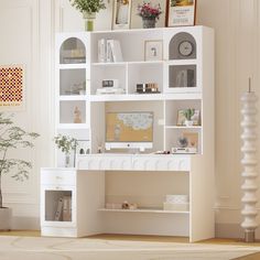 a white desk with shelves and pictures on the wall