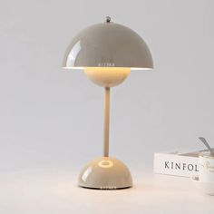 a lamp that is on top of a table next to a box with a pen in it