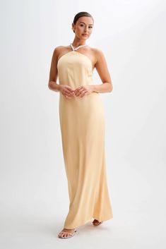 Classic sophistication.Glimpse the BLANCHE Satin Pearl Halter Maxi Dress, a symbol of timeless sophistication and elegance. Its halter neckline, adorned with pearl-trimmed straps, exudes refinement and grace. The pearl-adorned straps are made to be worn straight back or crossed for a customisable look. The low open back adds a touch of allure, while the maxi length ensures a captivating silhouette.Perfect for any special occasion, the Blanche Satin Pearl Halter Maxi Dress is sure to enchant with Capsule Wardrobe Accessories, Capsule Wardrobe Basics, Dress Peach, European Summer Outfits, Wardrobe Accessories, Maxi Dress Sale, Straight Back, Halter Maxi Dress, Capsule Outfits