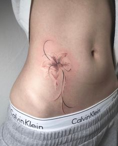 a woman's stomach with a flower tattoo on it