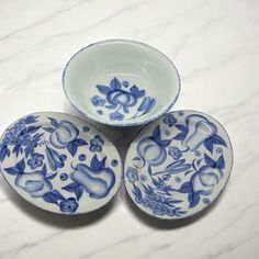 three blue and white bowls sitting on top of a marble counter next to each other