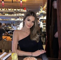 a woman sitting at a table with a plate of food