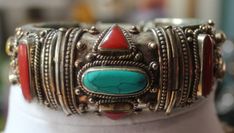 Listed above is a truly beautiful vintage, Middle Eastern, solidly carved sterling silver bangle bracelet, encrusted with turquoise, coral, yellow onyx and lapis stones. The bracelet has a security clasp which allows you to open the bracelet when putting it on. As you can see from the photos, tiny inserts of turquoise line the top and bottom rim of the bracelet. There is also a medallion of inlaid turquoise on the center inside back of the bracelet.  The circumference of the bracelet is 7 inches Collectible Gemstone Bangle Bracelets, Bohemian Sterling Silver Bangle Bracelet With Natural Stones, Bohemian Sterling Silver Bangle With Natural Stones, Handmade Vintage Turquoise Sterling Silver Bracelet, Vintage Handmade Turquoise Sterling Silver Bracelet, Vintage Natural Stones Cuff Bangle, Vintage Bangle Cuff Bracelet With Natural Stones, Vintage Cuff Bracelet With Natural Stones, Silver Bohemian Bangle With Natural Stones