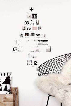 a white chair sitting in front of a wall with pictures on it and a christmas tree