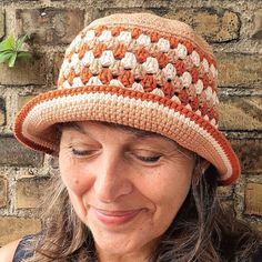 a woman is wearing a crocheted hat and smiling