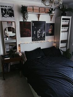 a bed with black sheets and lights in a room