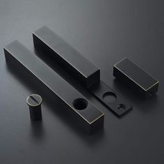 three black metal objects on a dark surface