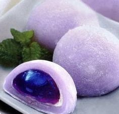 some kind of purple dessert on a plate with mint leaves and powdered sugar in the middle