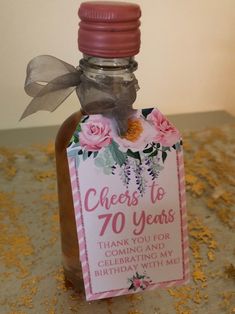 a bottle with a tag on it that says cheers to 70 years