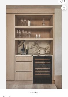 a kitchen with wine glasses and bottles on the counter top, next to an oven