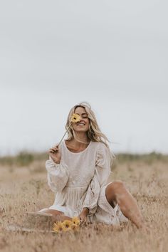 a woman sitting in the middle of a field with food on her face