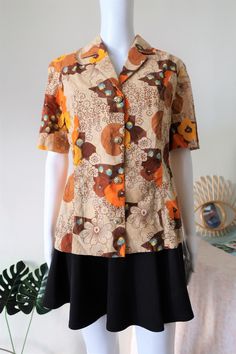 Stunning True Vintage blouse from the 1970s. Comfortable fabric, probably cotton or cotton mix. Amazing floral print in a beautiful color mix with ton-sur-ton embroidered structures in the fabric. Beautiful large golden buttons. BRAND: No brand label, probably custom made ERA: 1970s COLOR: Sand, brown, orange, yellow, blue FABRIC: No fabric tag, probably cotton or a cotton mix SIZE: No size tag, fits best size M - please check measurements below MEASUREMENTS: Pit to pit 48cm, total length 63cm C Vintage Brown Floral Print Tops, Vintage Cotton Shirt With Floral Print, Vintage Brown Blouse With Floral Print, Vintage Brown Floral Print Blouse, Brown Vintage Blouse For Spring, Vintage Brown Shirt For Spring, Vintage Patterned Button-up Blouse, Retro Cotton Blouse With Retro Print, Cotton Retro Blouse With Retro Print