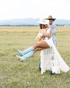 a man and woman dressed up in cowboy attire posing for a photo on the grass