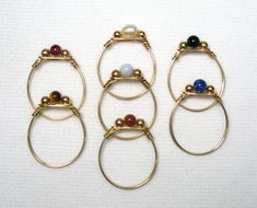 four rings with different colored stones on them