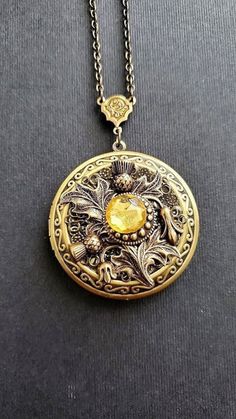 Large Flower Locket Necklace This necklace locket is bronze and copper, decorated with beautiful thistle flower that gives a vintage style cottage vibe. The piece is very involved and carefully made with a lot of detail. A lovely locket Necklace showcasing a yellow stone. See Photos for size comparison against American quarter Chain: ~ Antique Bronze Choose YOUR CHAIN LENGTH during checkout ☻More Lockets Here: https://www.etsy.com/shop/FashionCrashJewelry/search?search_query=lockets&order=date_d Luxury Vintage Round Pendant Locket Necklace, Vintage Jewelry Antique Necklaces, Steampunk Locket Jewelry Collectible, Steampunk Round Locket Jewelry, Steampunk Brass Locket Jewelry, Bronze Steampunk Jewelry With Engraving, Steampunk Bronze Engraved Jewelry, Gold Steampunk Jewelry With Copper, Gold Steampunk Jewelry Made Of Copper