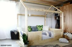 a bedroom with a bed made out of wooden planks and pillows on the floor