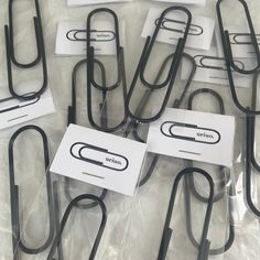 several black and white paper clips sitting on top of each other in clear plastic bags