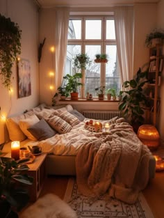 a bedroom with plants and candles on the windowsill