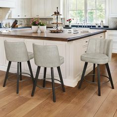 a kitchen island with three stools in front of it