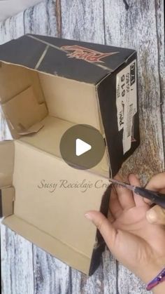 someone is cutting out the inside of a cardboard box that has been opened with scissors