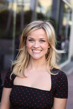 a woman in a polka dot dress smiles at the camera