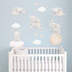 a baby's room with elephants and clouds on the wall