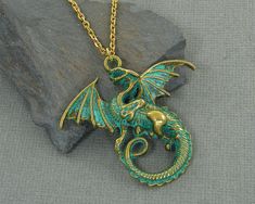 Dragon necklaces features a brass dragon with outstretched wings and verdigris green patina. Pendant is 1 11/16 inches tall, 1 13/16 inches wide (43 x 46mm). Gold plated chain - 18, 24 or 30 inches long. Find more women's necklaces here - https://www.etsy.com/shop/CharleneSevier?ref=hdr_shop_menu&section_id=10084290 Find more men's jewelry here - https://www.etsy.com/shop/CharleneSevier?ref=hdr_shop_menu&section_id=10866473 Enter my shop here - https://www.etsy.com/shop/CharleneSevier?re Gold Fantasy Style Necklace For Fantasy Events, Vintage Dragon Design Jewelry For Gifts, Vintage Dragon Design Jewelry Gift, Vintage Jewelry With Dragon Design Gift, Vintage Jewelry With Dragon Design For Gift, Gold Fantasy Necklace With Dragon Design, Gold Fantasy Dragon Necklace, Fantasy Dragon Design Necklace, Gold Fantasy Jewelry With Dragon Design