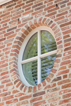 a round window on the side of a brick building