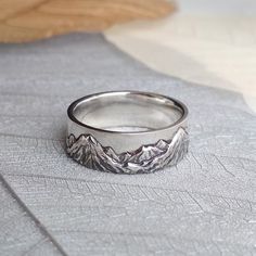 a silver ring with mountains on it