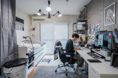 two people sitting at desks in an apartment