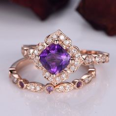 an engagement ring with a purple stone surrounded by diamonds