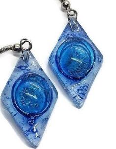 Blue glass Earrings. These earrings are handmade of recycled glass. The bubbles are unpredictable the form during the firing process and they give each bead some character and uniqueness! The glass bead is about 1.2 inches long, 0.6inches wide. The earring from the hook to the bottom of the glass is aprox 1.9 inches long Sterling silver fish hook wires. All the earrings come with rubber back stoppers. The glass is cut, painted and fired in a kiln. the bead is about one inch long and the finished Blue Recycled Glass Dangle Earrings, Nickel-free Blue Recycled Glass Earrings, Blue Recycled Glass Nickel-free Earrings, Blue Resin Teardrop Earrings, Blue Nickel-free Recycled Glass Earrings, Blue Round Recycled Glass Jewelry, Blue Recycled Glass Round Jewelry, Dichroic Glass Jewelry, Fused Glass Earrings