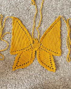 a yellow crocheted butterfly is laying on the floor